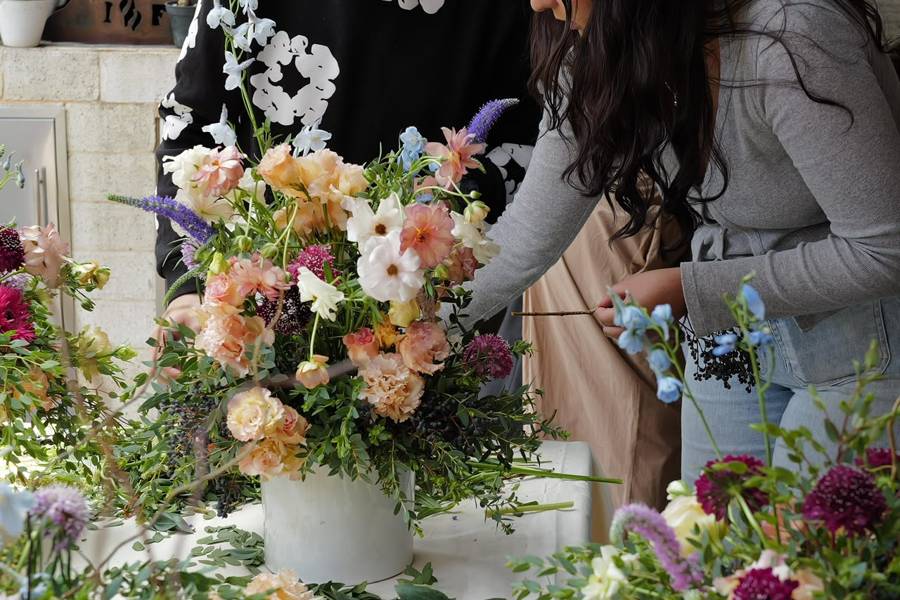 Persona arreglando un ramo floral abundante